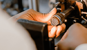 A circular connector being assembled by hand.