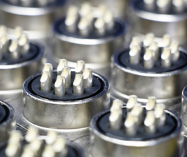 Close-up of circular metal electrical connectors with gold-plated pins arranged in rows